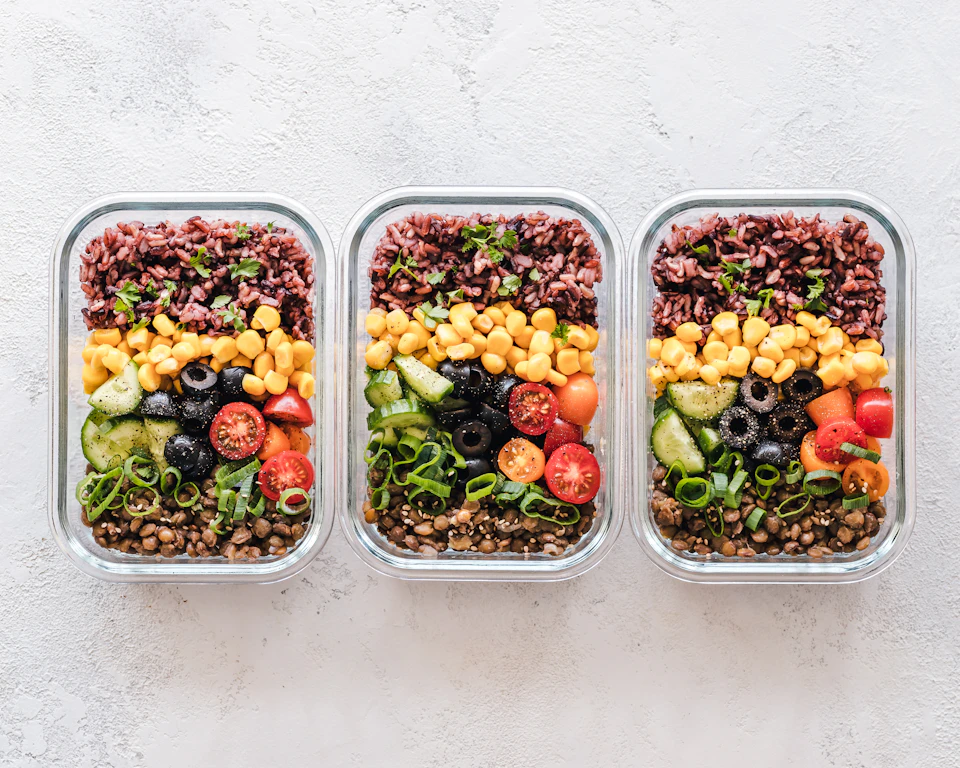 Colourful balanced meals with rice, vegetables and lentils prepared in glass containers